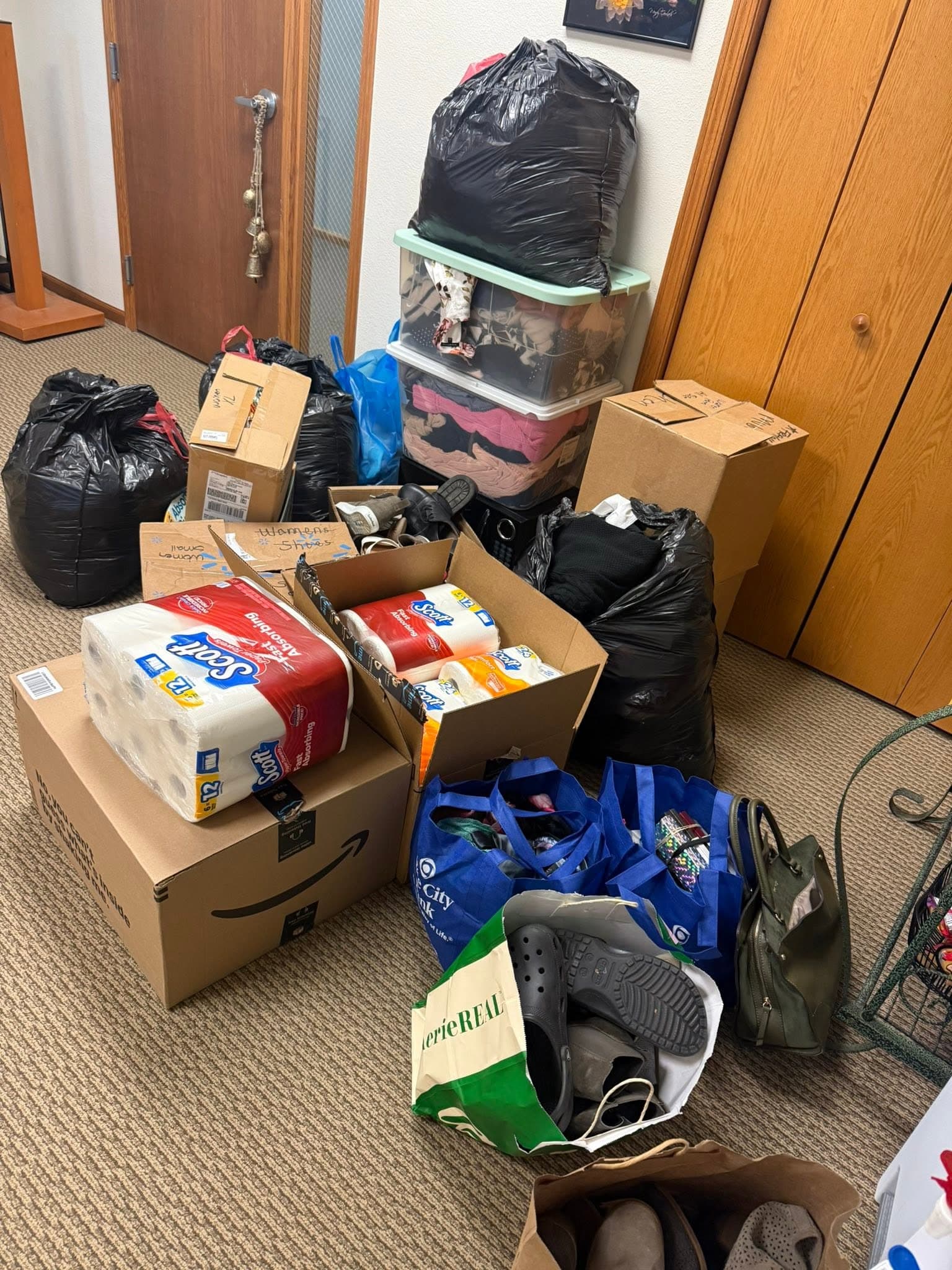 Bags, boxes, shoes and household goods stacked inside the Blame Bates office doorway.