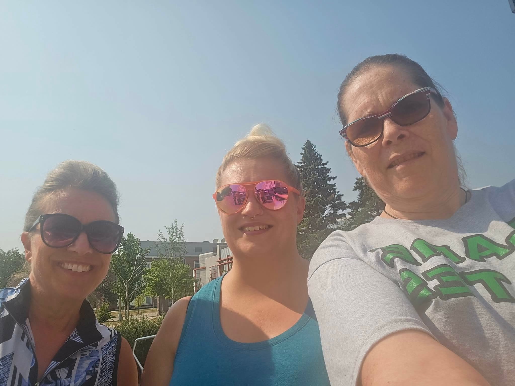 Three Blame Bates team members together outdoors.